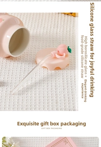 Close-up of pink glass straw with peach silicone cap on white waffle fabric background