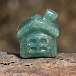 Macro shot of green natural jade crystal small house carving with unique stone texture