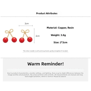 Detail showing red cherry earrings with golden bow, resin material, 2x2cm size specifications