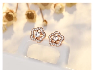 Detailed view of rose gold flower stud earrings with sparkling zircon micro-pave