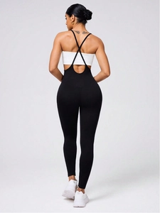 Slim fit black one-piece yoga jumpsuit with crisscross straps and open back detail