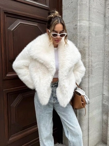 Close-up of white faux fur coat featuring fluffy texture and luxury oversized lapels