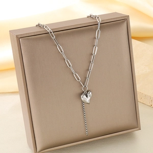 Détail du pendentif cœur argenté à texture irrégulière et chaîne style trombone