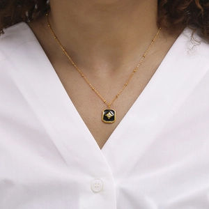 Vintage gold plated stainless steel necklace with black star pendant worn by a model