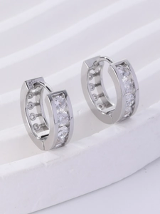 Macro shot of silver hoop earrings with clear cubic zirconia in a prong setting