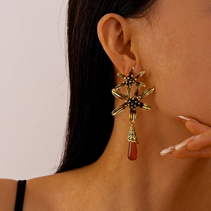 Detailed close-up of vintage gold flower earrings with amber water drop tassels on model