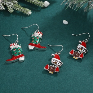 Christmas candy cane boot and owl earrings on a dark green festive background