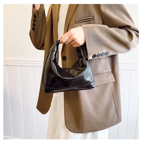Close-up of black PU leather dumpling bag featuring embossed PROMISE lettering detail