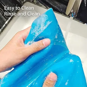 Blue thick silicone pastry mat shown being rinsed under water for easy cleaning