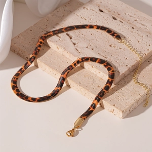 Detail of leopard print snake bone necklace with gold lobster clasp on stone tray