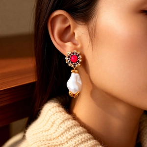 Nahaufnahme von Vintage Blumenohrringen mit roter Emaille und Barockperle am Model