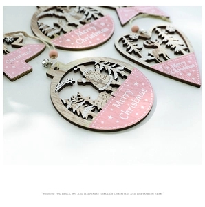 Close-up of pink and natural wood laser-cut Christmas ornaments with Merry Christmas text