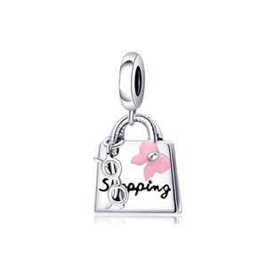 Macro shot of silver handbag charm with pink bow and Shopping text detail