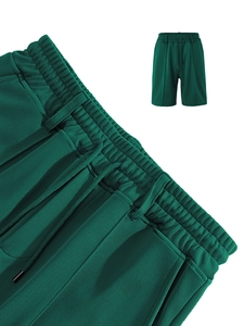 Detail of dark green quick-dry mesh shorts showing drawstring elastic waistband and texture