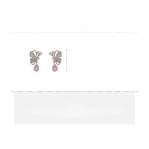 Detail of butterfly drop earring with pink teardrop gemstone and zircon accents