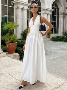 Detail of white halter V-neck maxi dress with textured cotton fabric and elegant waist tie