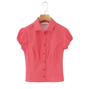 Close-up of red puff sleeves and white polka dot pattern on a button-up shirt