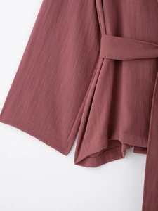 Detailed texture of dusty rose kimono jacket with waist belt and wide cuff design