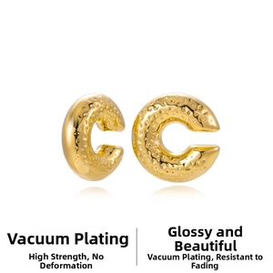 Detail of gold-plated stainless steel C-shape earrings with hammered texture finish