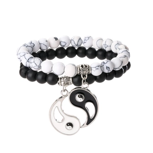 Close-up of black matte and white turquoise beads with a Yin Yang split charm pendant