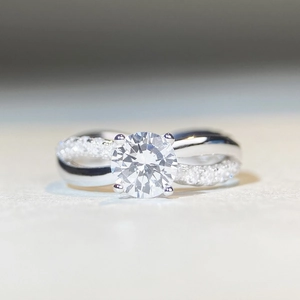 Macro shot of 1 carat round moissanite ring with classic four-prong and twisted band