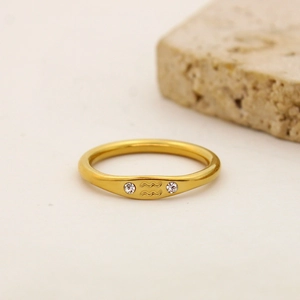 Close-up of golden Aquarius zodiac ring with tiny crystals on a minimal stone base
