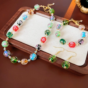 Macro detail of colorful glazed glass beads jewelry set on a rustic wooden display tray
