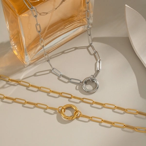 Close-up of gold and silver paperclip chain necklaces with O-ring clasp detail