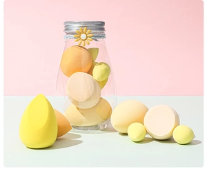 Detailed view of yellow and orange makeup sponges in a floral clear storage container