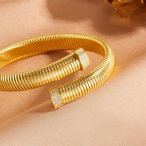 Gros plan d'un bracelet ressort doré avec cristaux scintillants sur tissu en soie