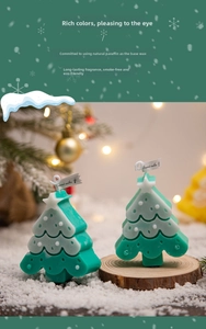 Detailed view of green Christmas tree scented candle with snow decor and star topper