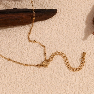 Detailed close-up of the 18K gold plated lobster clasp and adjustable extension chain