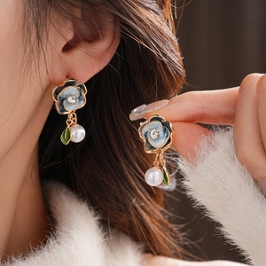 Detailed close-up of retro floral pearl earrings with blue enamel and crystal accents