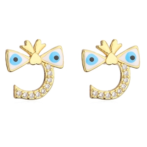 Close-up of golden Evil Eye stud earrings with bow tie and sparkling pavé crystals