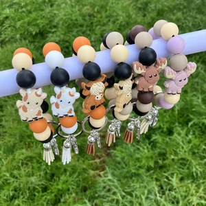Silicone bead keychain bracelets with cute animal charms and tassels on green grass
