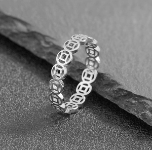 Macro detail of silver ancient Chinese coin ring with wealth symbol on slate background