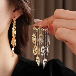 Détail de boucles d'oreilles à pampilles en zircon doré et argenté avec chaînes étagées