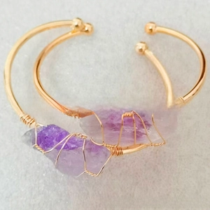 Detailed wire-wrapped gold-plated bracelet featuring raw purple amethyst crystals