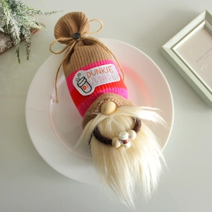 Coffee gnome doll with striped knit hat and white beard on a decorative white plate
