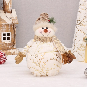 Close-up of plush Christmas snowman doll with gold snowflake patterns and a knit hat