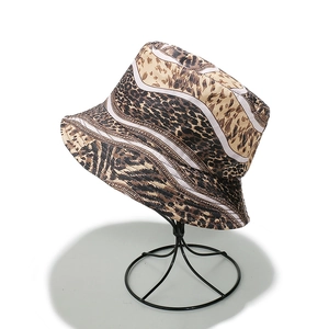 Dettaglio della trama leopardata e strisce bianche su un cappello da sole in tela