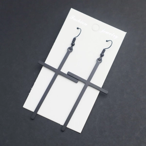Minimalist matte black long cross drop earrings displayed on a white fashion jewelry card