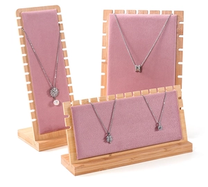 Macro detail of pink velvet and solid wood jewelry display stands for necklaces
