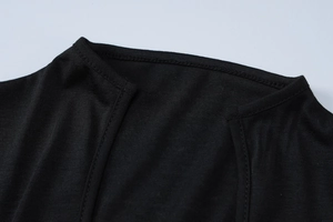 Close-up of the deep V-neckline and detailed knitted fabric texture of the black dress