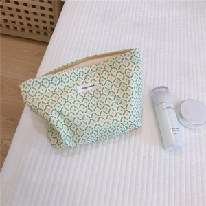 Detail of floral cotton makeup bag with green leaves, pink flowers and zipper closure