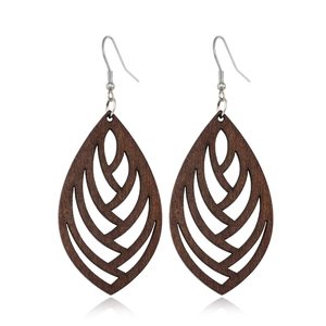 Detailed view of hollow wooden leaf earrings with silver hooks on white background