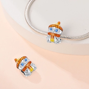 Detail of 925 silver plated owl charm with orange and yellow enamel on a bracelet