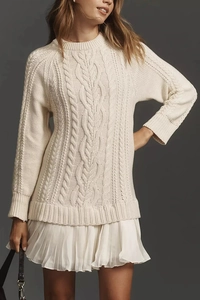 Détails de tricot torsadé sur pull à manches longues blanc cassé avec ourlet plissé