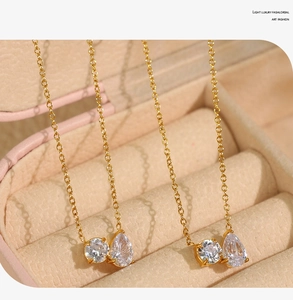 Macro shot of gold necklace featuring teardrop and round white zircon stone pendants