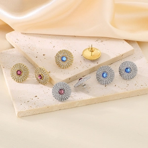 Detail shot of vintage sunburst earrings with colorful crystals on textured stone base